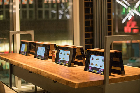 Mesa de restaurante con menús electrónicos retráctiles