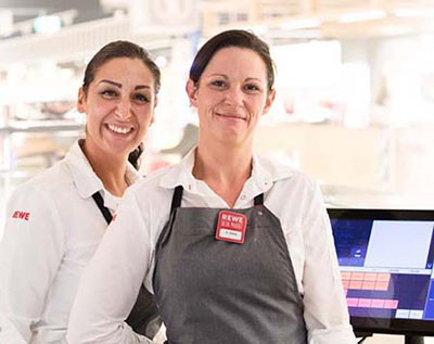 Supermarket cashiers in front of a checkout
